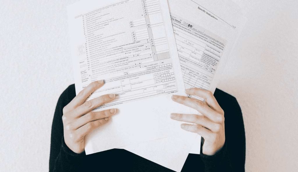cartelle esattoriali stampate che nascondono il volto